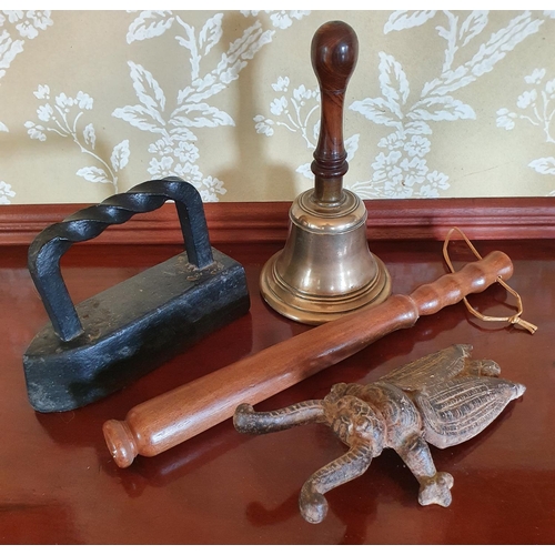 291 - A hand bell, 28 cm high, a beetle boot pull, a flat iron door stop, and a truncheon (4)