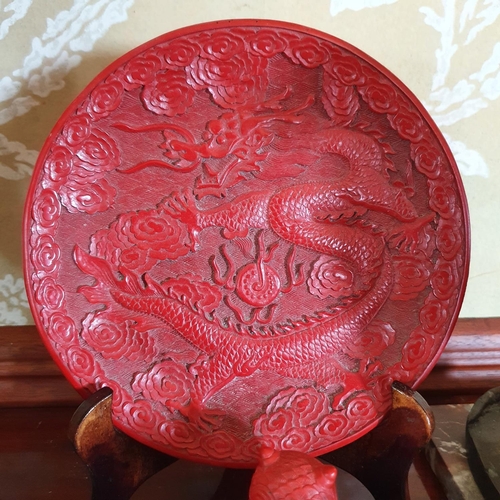 299 - A Chinese red lacquered dish, decorated a dragon, 20 cm diameter, a bronze bell, and other items (bo... 