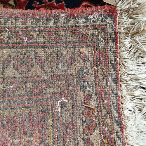 320 - A small Persian rug, with a central lozenge on a salmon pink ground, 145 x 70 cm, and another simila... 