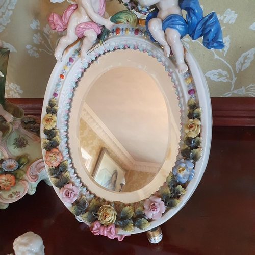 338 - A late 19th century Dresden type porcelain strut mirror, mounted with cherubs and flowers, some dama... 