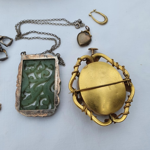 342 - A Chinese carved and pierced jade pendant, in a silver coloured metal mount, on a chain, a late Vict... 