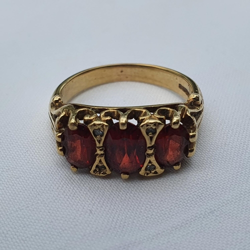 346 - A 9ct gold and garnet three stone ring