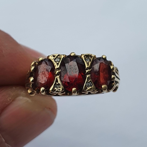 346 - A 9ct gold and garnet three stone ring