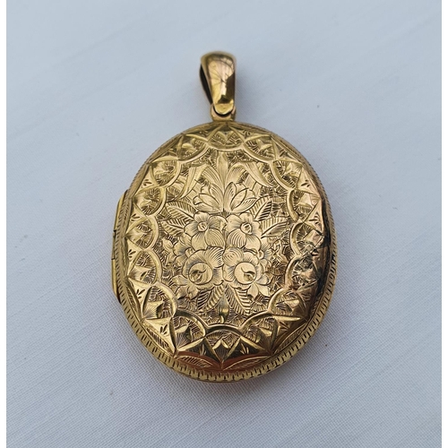 351 - A yellow coloured metal oval pendant, with engraved decoration