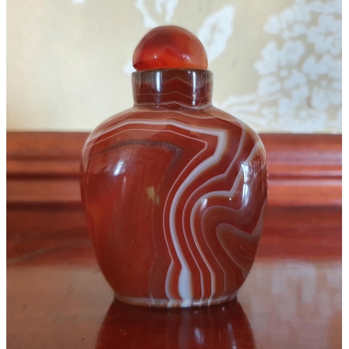 389 - A Chinese agate snuff bottle and stopper, carved a mountain scene, 9 cm high, stopper detached