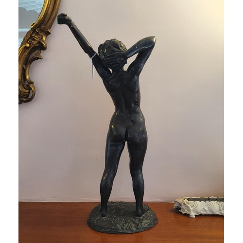 472 - A bronzed figure of a nude lady, stretching, 59 cm high