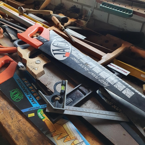 131 - A group of assorted saws, spirit levels, axes, and other tools, all on top of the work bench (exclud... 