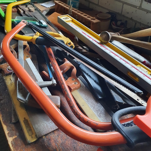 131 - A group of assorted saws, spirit levels, axes, and other tools, all on top of the work bench (exclud... 