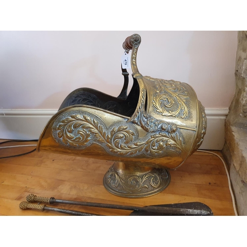 479 - A Victorian brass helmet shaped coal scuttle, with embossed decoration, a shovel, with a set of thre... 