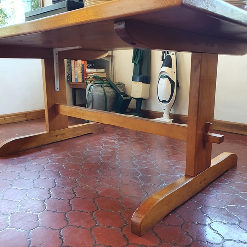 543 - A pine kitchen table, and end supports joined by a stretcher,  167 cm wide x 114 cm deep x 74 cm hig... 