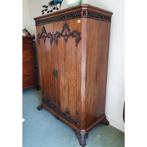 592 - An 18th century style mahogany wardrobe, having a pair of doors with rococo style decoration, of lea... 