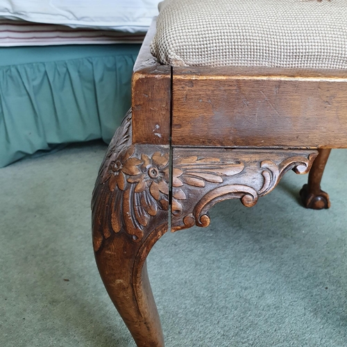 596 - An 18th century style carved walnut stool, on cabriole legs with claw and ball feet, 58 cm wide