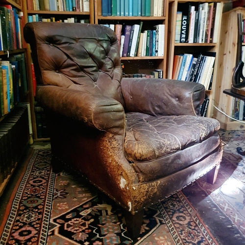 653 - The Attic. 
A leather upholstered country house armchair, in need of repair, some buttons missing fr... 