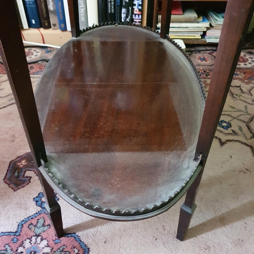 660 - An Edwardian mahogany table vitrine, of lobed oval form, on tapering reeded legs joined by an undert... 