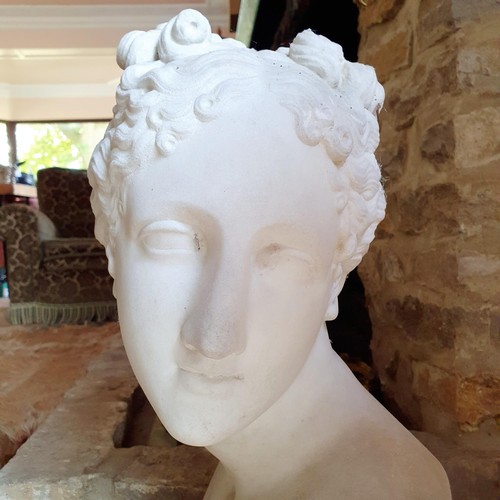 477 - A late 19th/early 20th century carved marble bust, of a lady with her hair tied up, on a socle base,... 