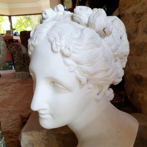 477 - A late 19th/early 20th century carved marble bust, of a lady with her hair tied up, on a socle base,... 