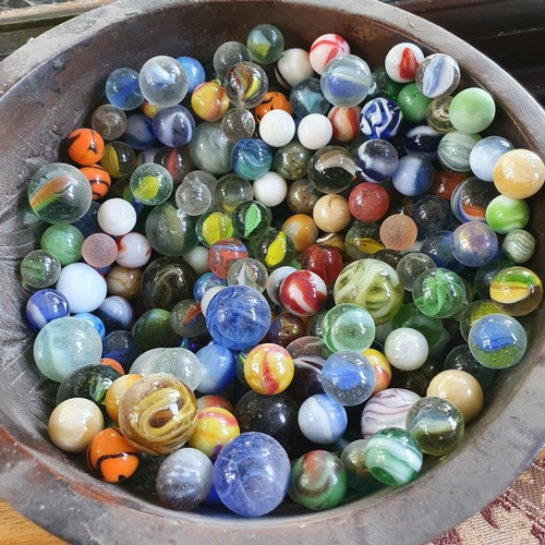 518 - Assorted marbles, a glass wasp trap, a pottery vase, and a wooden bowl