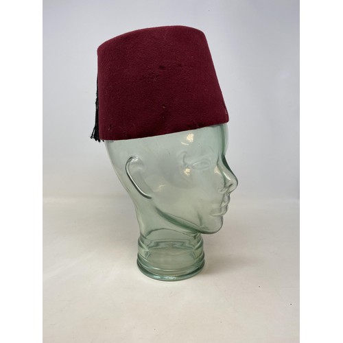 560 - A glass bust, 35 cm high and a vintage fez