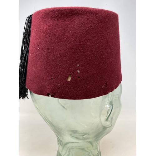 560 - A glass bust, 35 cm high and a vintage fez