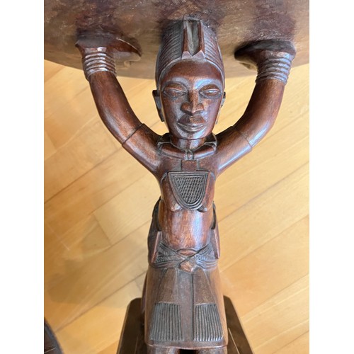 221 - An African low table, on a carved figural support, 45 cm high