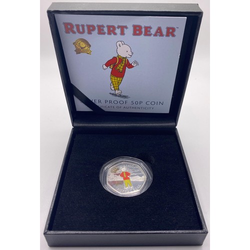 198 - A silver proof Rupert Bear 50p piece, three other commemorative coins, and a VE medal set