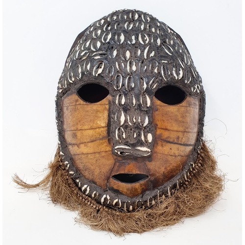 583 - A turtle carapace tribal mask, pierced and decorated shells, 28 cm high