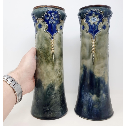 584 - A pair of Royal Doulton vases, of slender waisted form, decorated foliage, one chipped, 32 cm high (... 