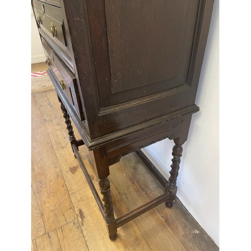 744 - An oak chest on stand, having four drawers on a base with barley twist legs, 132 cm high x 70 cm wid... 