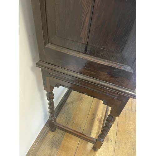 744 - An oak chest on stand, having four drawers on a base with barley twist legs, 132 cm high x 70 cm wid... 