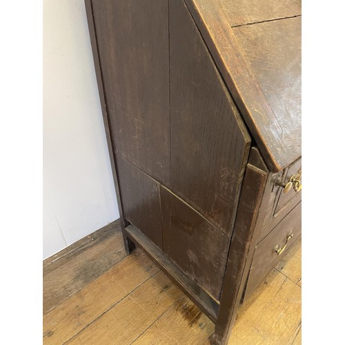 754 - An oak bureau bookcase, the top having two cupboard doors, above a fall front with a fitted interior... 