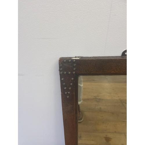 760 - A triptych mirror, in a studded leather frame, 94 x 138 cm