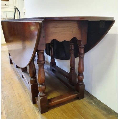 844 - A large 18th century style oak double gateleg table, 230 cm wide