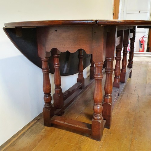 844 - A large 18th century style oak double gateleg table, 230 cm wide