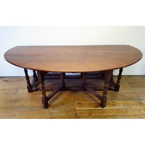 844 - A large 18th century style oak double gateleg table, 230 cm wide