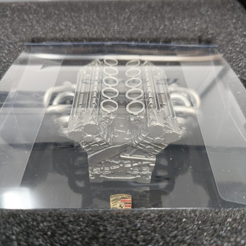 96 - A model of a Porsche Carrera GT engine, with a video cassette and book, in an aluminium presentation... 