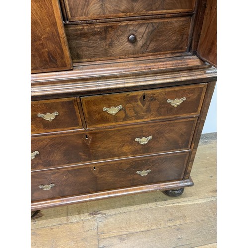 481 - An 18th century walnut cabinet on chest, with two cupboard doors, to reveal an interior with drawers... 