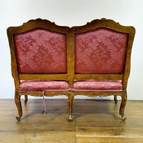 545 - An early 20th century carved wood and gilt framed double armchair, with a padded back, arms and seat... 