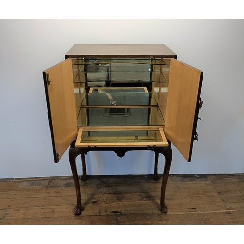 556 - A walnut and brass bound cocktail cabinet, raised on carved cabriole legs, 85 cm wide