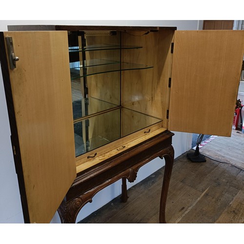 556 - A walnut and brass bound cocktail cabinet, raised on carved cabriole legs, 85 cm wide