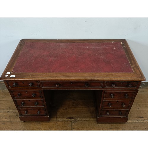 565 - A mahogany pedestal desk, having a nine drawer configuration, 120 cm wide