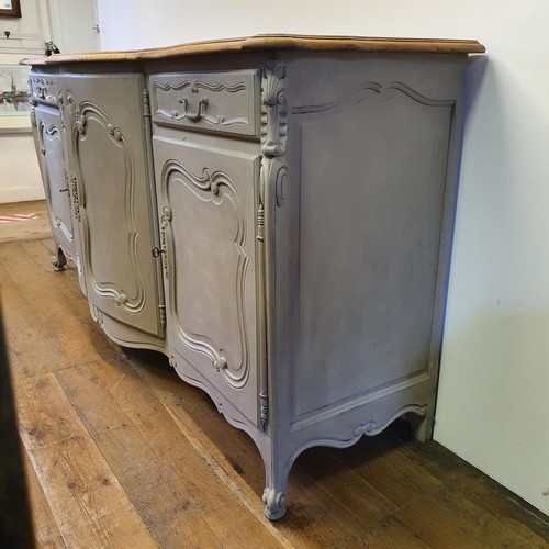 486 - A French oak serpentine sideboard, with a painted front, having two cupboard doors, flanked by two d... 