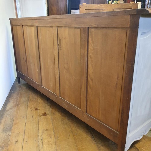 486 - A French oak serpentine sideboard, with a painted front, having two cupboard doors, flanked by two d... 