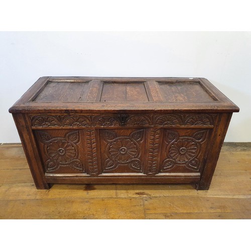 485 - An 18th century oak coffer, with a later carved front, 120 cm wide