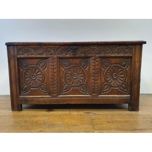 485 - An 18th century oak coffer, with a later carved front, 120 cm wide