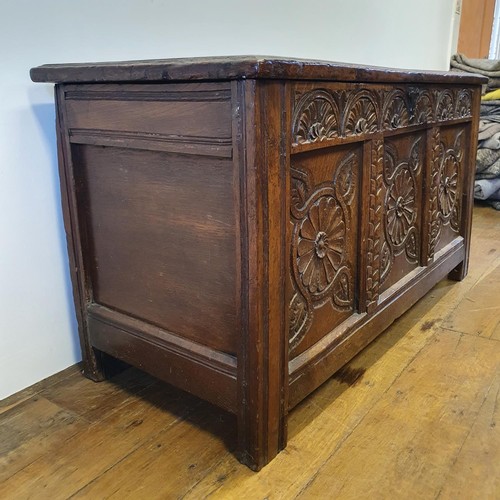 485 - An 18th century oak coffer, with a later carved front, 120 cm wide