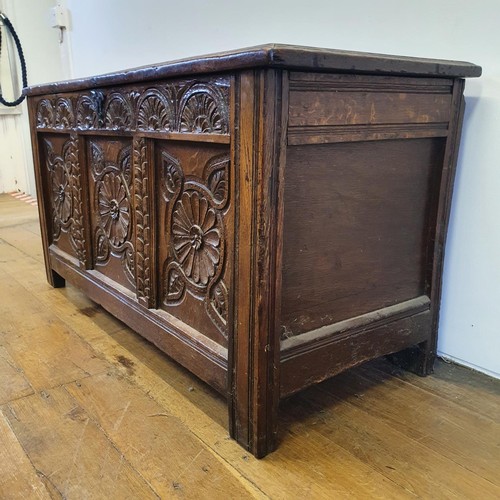 485 - An 18th century oak coffer, with a later carved front, 120 cm wide