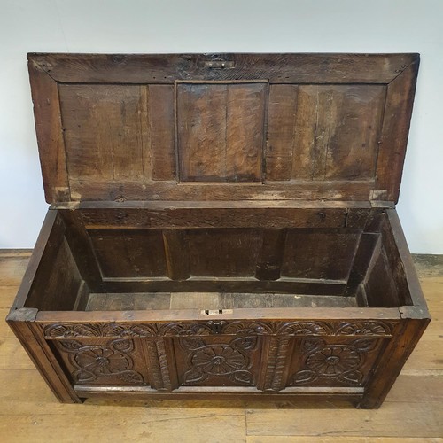 485 - An 18th century oak coffer, with a later carved front, 120 cm wide