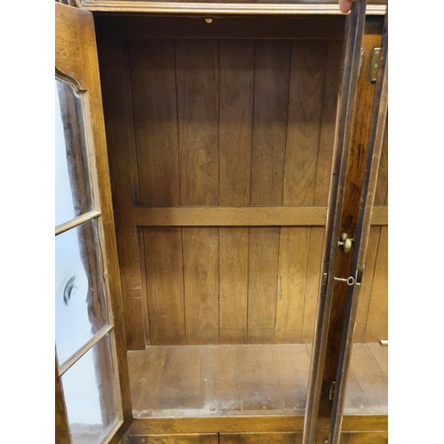 575 - An oak cabinet, having four glazed doors, 134 cm wide