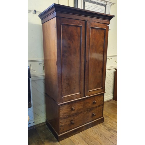 573 - A 19th Century mahogany linen press, two cupboard doors to reveal shelves, on a base with two drawer... 