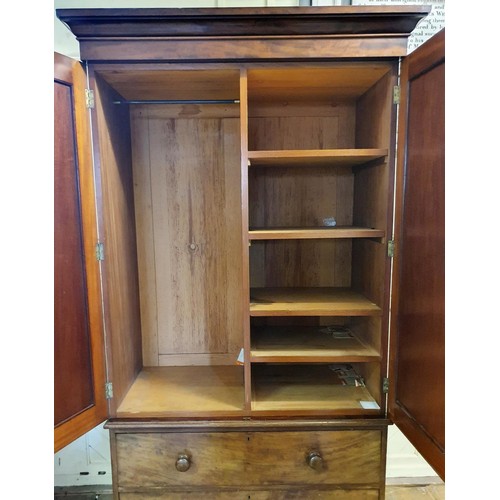 573 - A 19th Century mahogany linen press, two cupboard doors to reveal shelves, on a base with two drawer... 